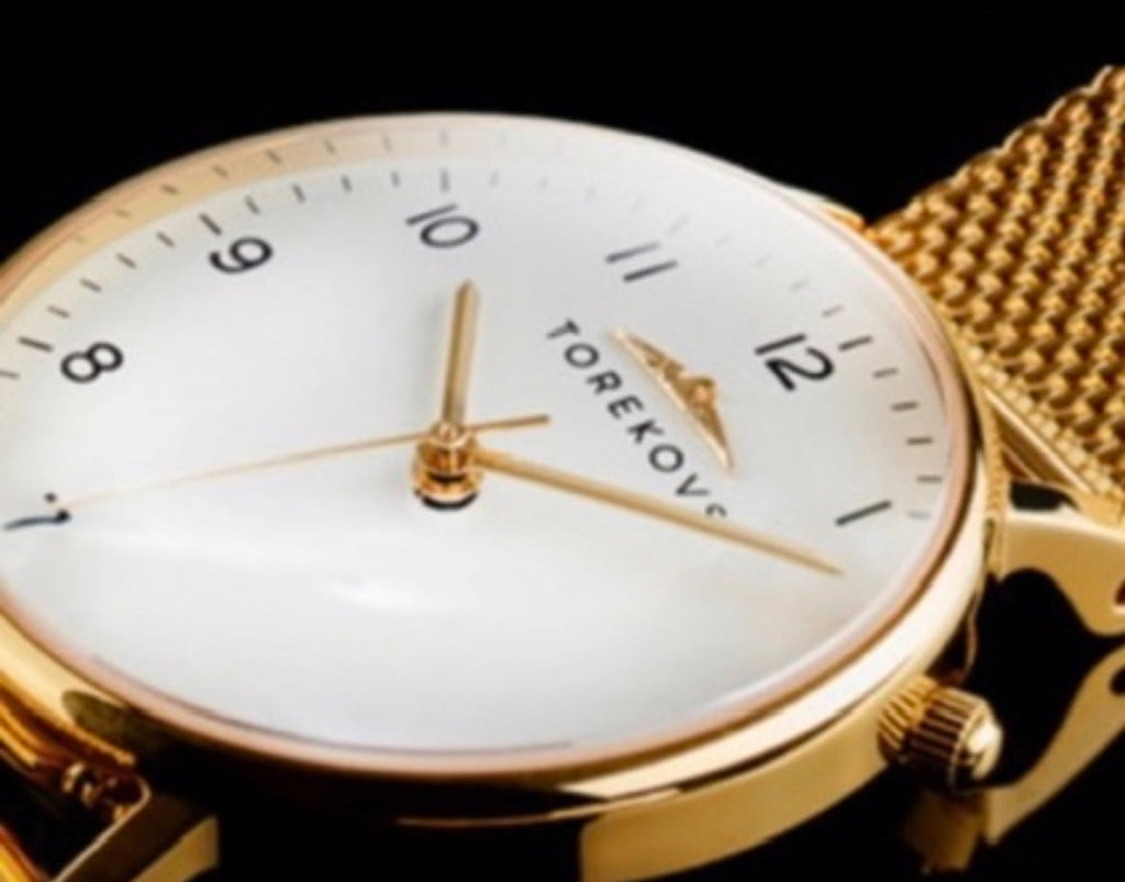 Närbild på exklusiv Guld klocka dam från svenska Torekovs med mjukt mesh-armband och reptåligt safirkristallglas